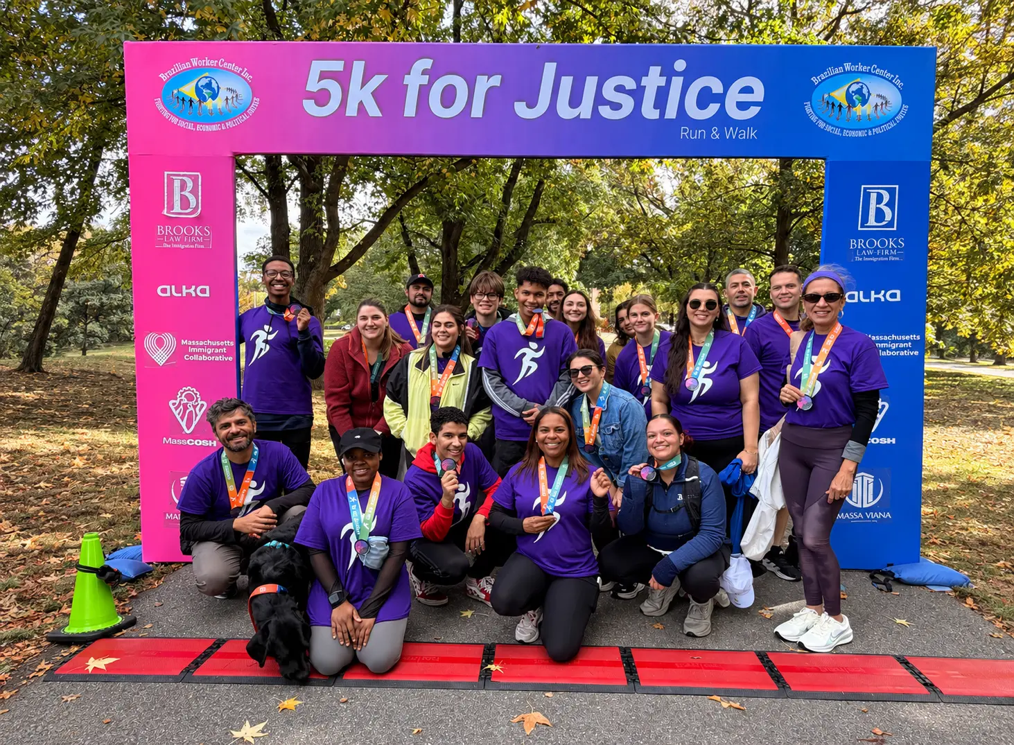 Runners, volunteers and partners of the 5K for Justice at the finish line arch